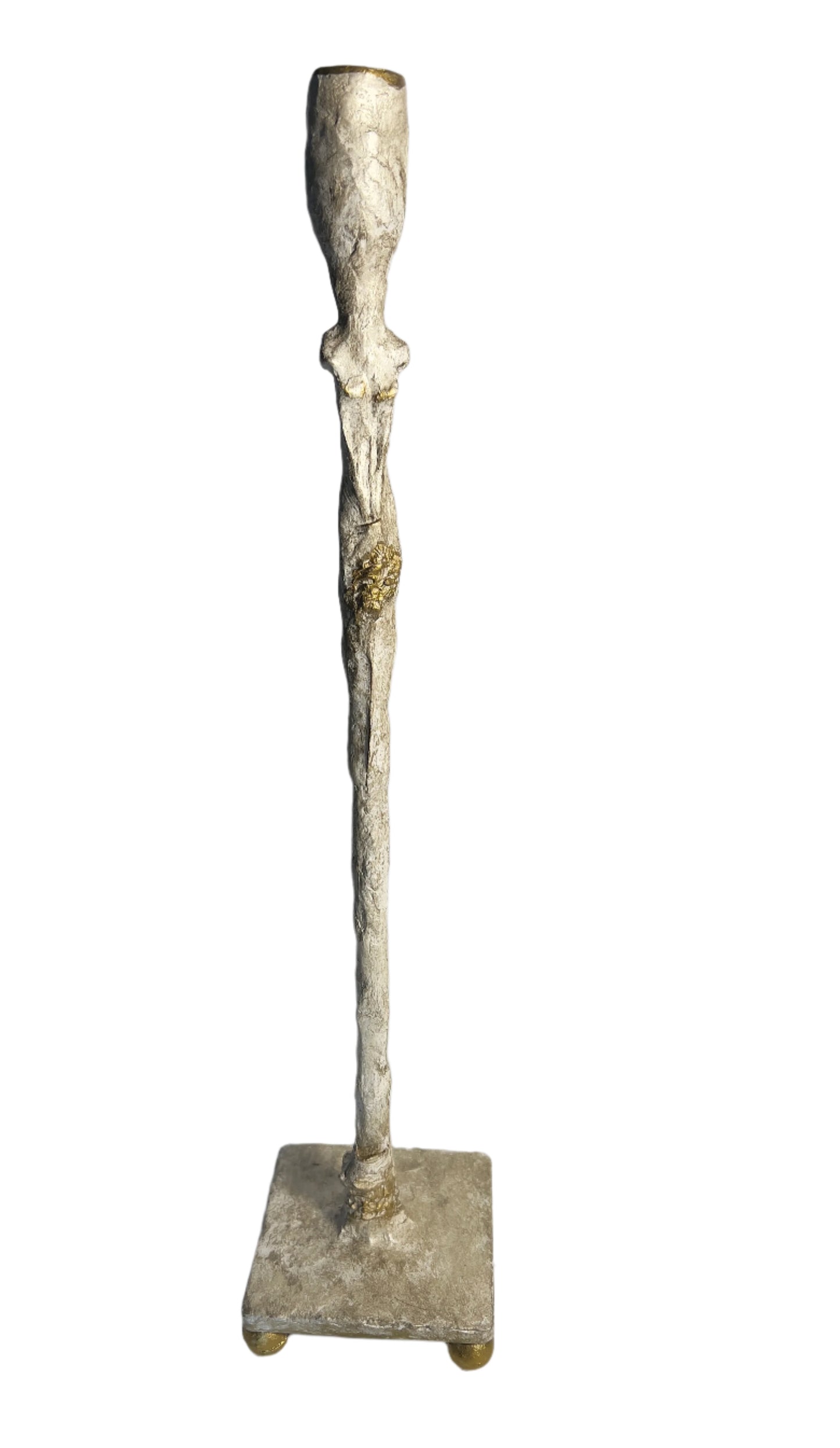 Decorative metal candle holder on a white surface with a light gray background