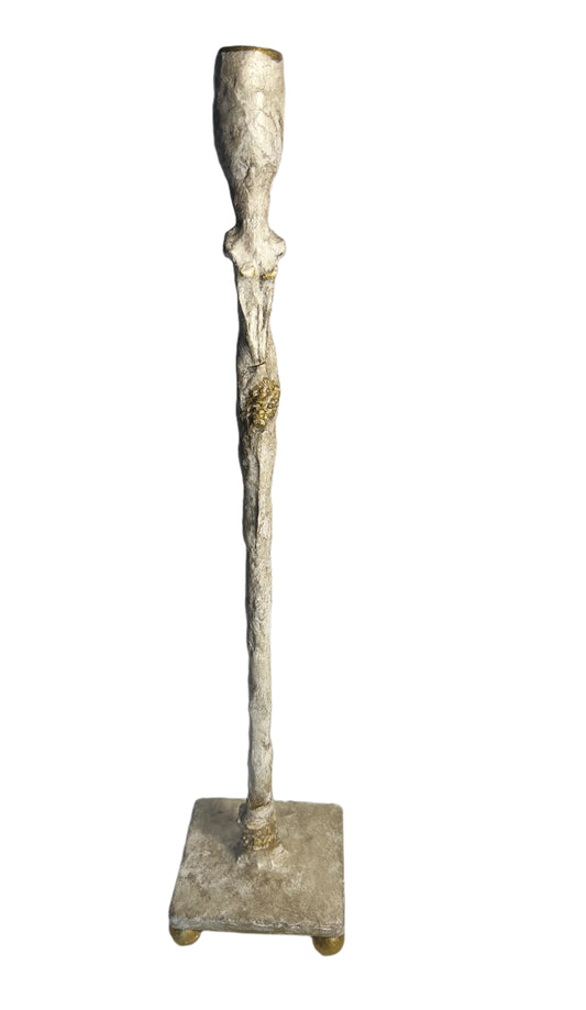 Decorative metal candle holder on a white surface with a light gray background